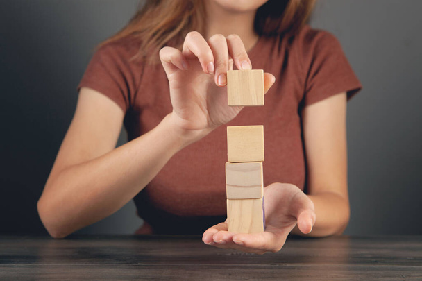 woman holding a tower of wooden cubes - Photo, Image