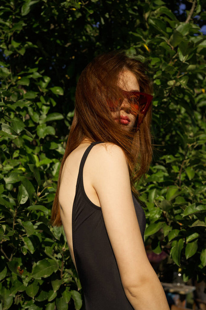 woman in black swimsuit sunglasses nature summer posing - 写真・画像
