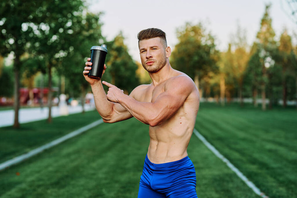athletic man with pumped up muscular body in the park exercise workout motivation - Foto, immagini