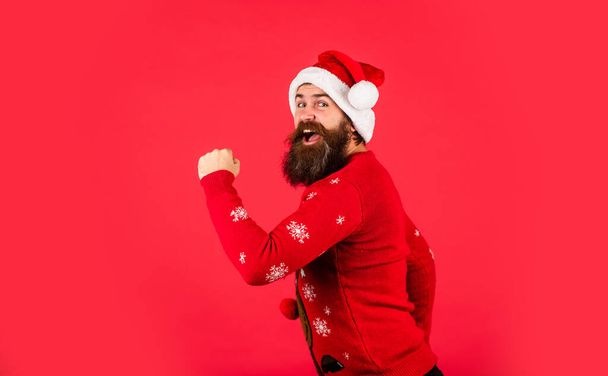 lets go shopping. happy caucasian guy await new year present. lets have fun. Santa Claus hipster. handsome man at Christmas. brutal bearded male red background. party man in Christmas sweater - Фото, изображение