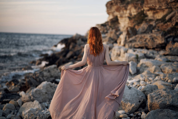 woman in dress rocky stones landscape ocean nature silhouette - Фото, изображение