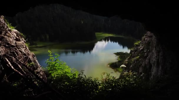 hd widok z jaskini do niesamowicie pięknego górskiego jeziora na Austrii podczas wędrówki - Materiał filmowy, wideo