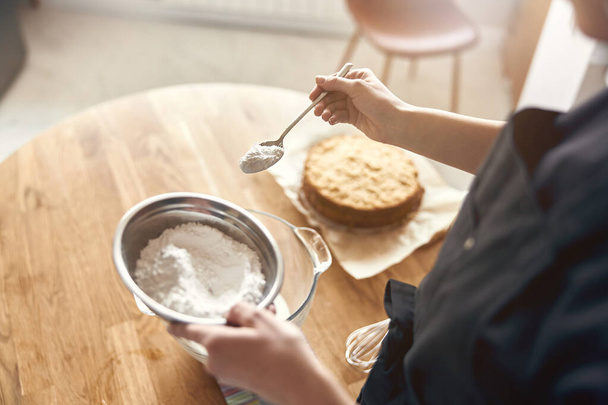 mladá profesionální kuchařka připravuje chutný dort ve své lehké moderní kuchyni - Fotografie, Obrázek