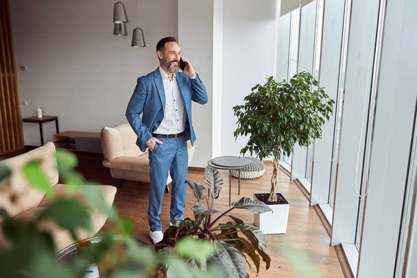Happy adult caucasian man is working in a modern office - Zdjęcie, obraz