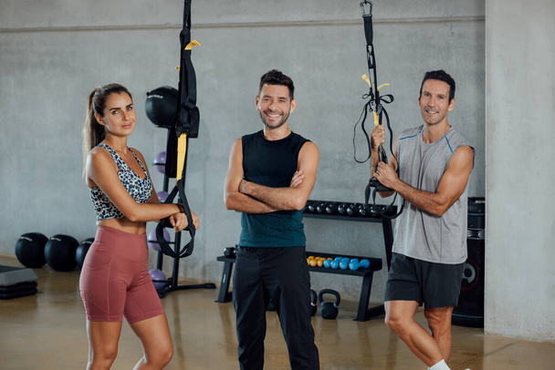 Group of sportive people standing and looking at camera posing in a gym. - Foto, Imagem