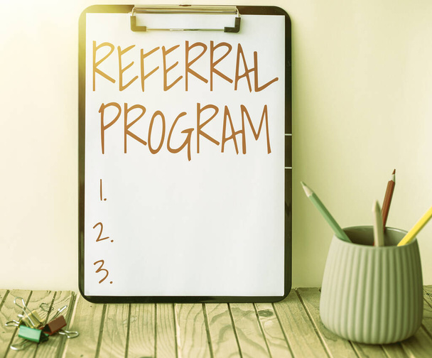 Conceptual caption Referral Program. Word Written on internal recruitment method employed by organizations Plain Office Clipboard With Stacks Of Pens In A Holder Placed On A Table. - Photo, Image