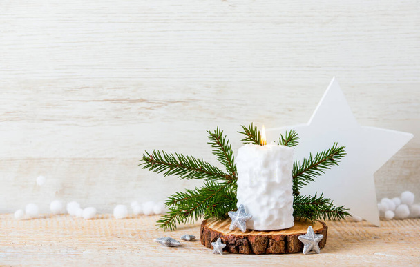 Vintage Nordic style minimalist Christmas background with a lot of copy space. Selective focus on snow ball pattern white candle burning, star shape decorations for decoration on wood background. - Foto, afbeelding