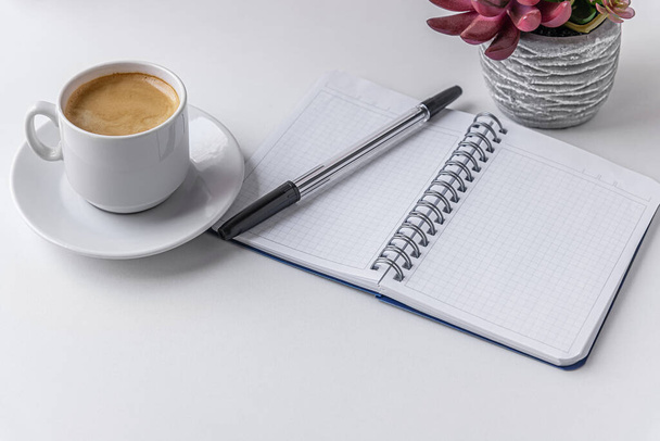 чашку кофе, блокнот, перо и сочный в горшке на белой поверхности - Фото, изображение