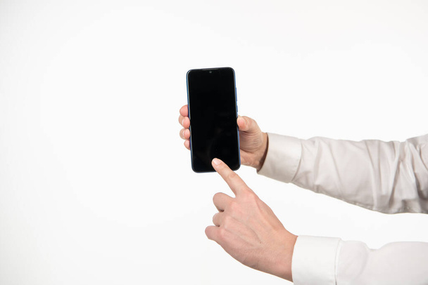 Telefon ekranını sunan bir adamın eli. beyaz üzerinde izole akıllı telefon parmakla parmakla - Fotoğraf, Görsel