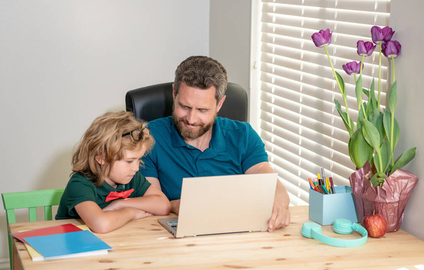 iloinen isä ja lapsi poika koulussa työskentelevät verkossa kannettavan, koulutus - Valokuva, kuva