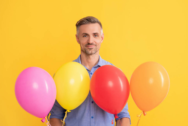 seasonal sales. man with party balloons. present and gifts buy. mature shopping guy with purchase - Фото, изображение