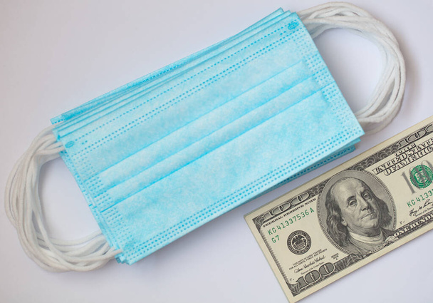 surgical masks and 100 dollar banknote - Foto, Bild