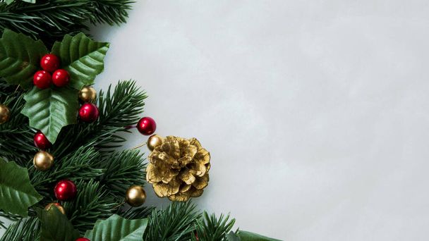 Рождественские украшения, листья сосны, мячи, ягоды на белоснежном фоне, рождественская концепция - Фото, изображение