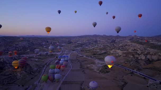 Kapadokya, Türkiye - 14 Eylül 2021: Bir grup Sıcak Hava Balonu doğal şekilli kaya oluşumuyla Goreme Vadisi üzerinde özgürce uçuyor. - Video, Çekim