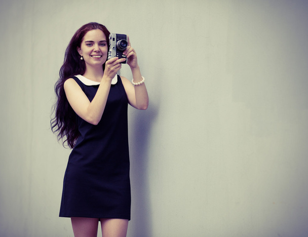 Beautiful sexy brunette with long hair with vintage camera in hand. Colorful hipster photo - Fotoğraf, Görsel