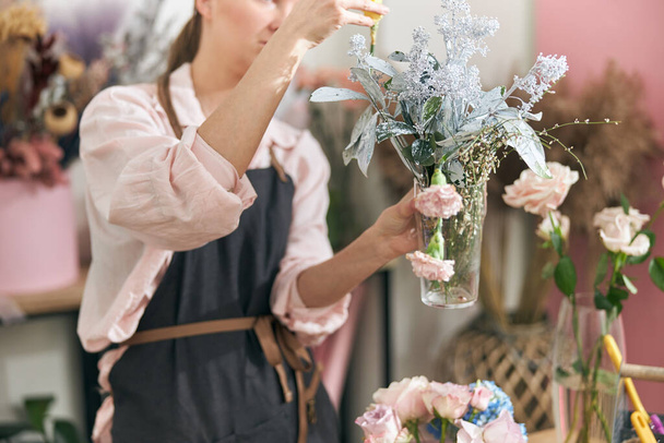 Florista profesional mujer joven está haciendo ramos en la tienda de flores - Foto, imagen