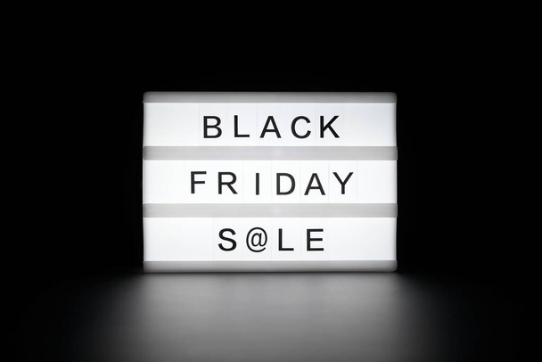 Black Friday Sale está escrito em uma caixa de luz brilhante em um fundo escuro. - Foto, Imagem