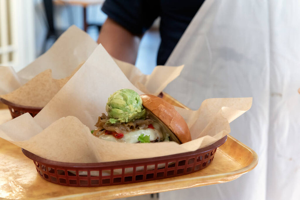 Cameriere portare al ristorante hamburger e panini su un vassoio con indosso un grembiule. - Foto, immagini