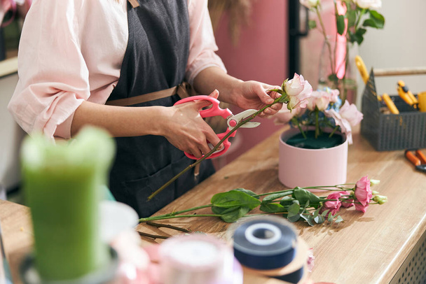 Florista profesional mujer joven está haciendo ramos en la tienda de flores - Foto, imagen