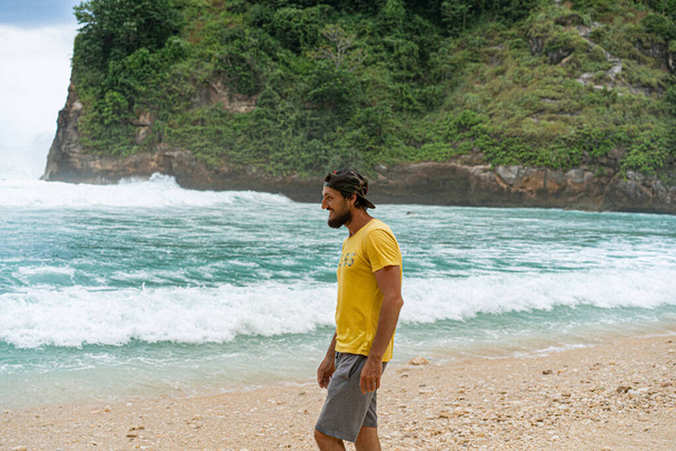 Young handsome bearded man traveler by the ocean. Travel concept - Photo, Image