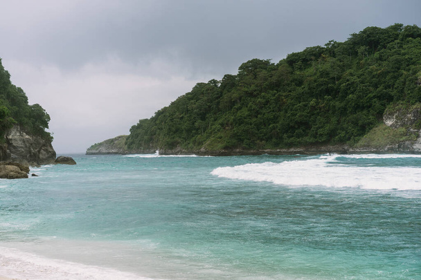 View of tropical beach, sea rocks and turquoise ocean, blue sky. - Фото, зображення