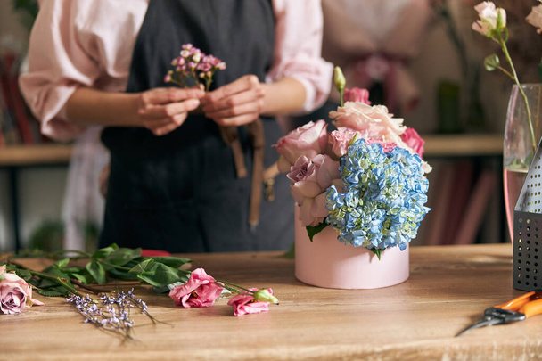Fiorista professionista giovane donna sta facendo mazzi di fiori al negozio di fiori - Foto, immagini