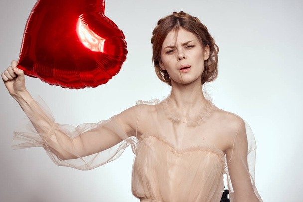 cheerful woman red heart in the hands of the balloon model studio - Foto, imagen