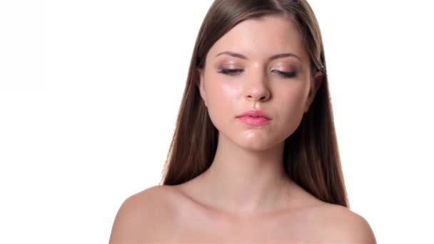 Beautiful woman applying make up on white background - Filmati, video