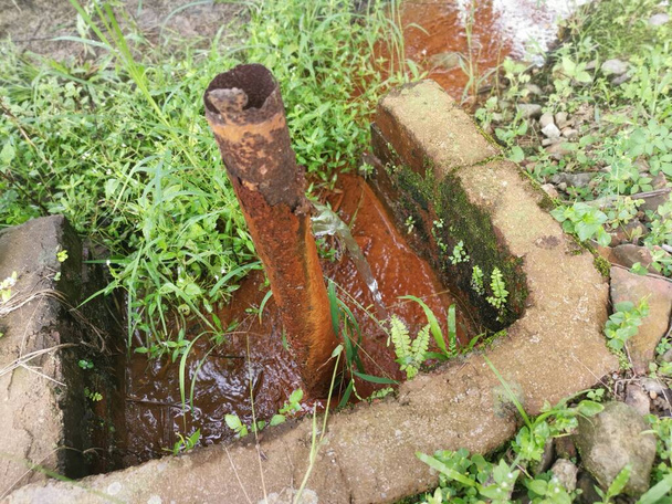 Korrodierte Wasserleitung auf der Hofwiese. - Foto, Bild