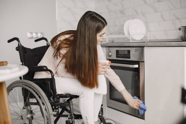 Young Handicapped Woman On Wheelchair Cleaning Stove - Φωτογραφία, εικόνα