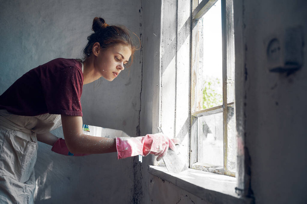 woman painter paints window with brush renovation interior decoration - Фото, изображение