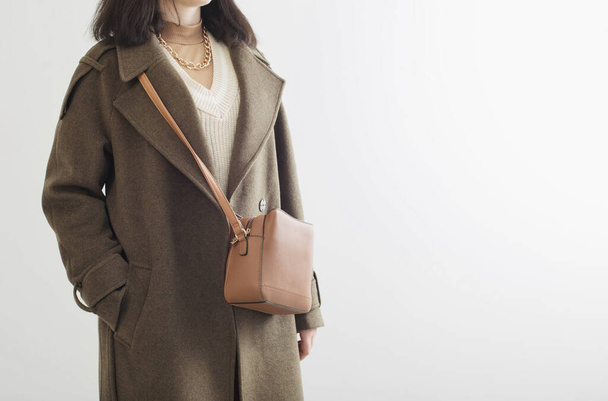  woman in autumn coat with handbag on white background - Foto, afbeelding