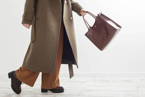 woman in autumn coat with handbag in white room - Photo, Image