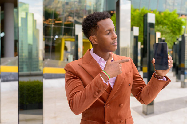 Portrait de beau jeune homme d'affaires africain noir portant des vêtements élégants - Photo, image
