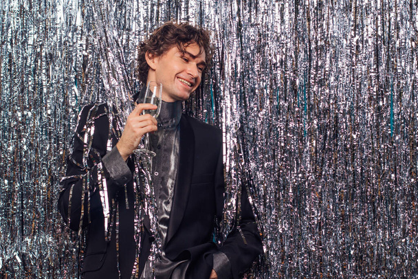 Holidays concept - happy tipsy man with bottle of champagne and wine glass at christmas or new year party on a sparkle background. - Fotoğraf, Görsel