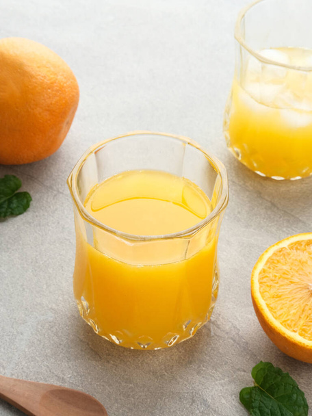 Orange juice in glass with mint, fresh fruits on wooden board. Selective focus and blurred background. - Foto, immagini