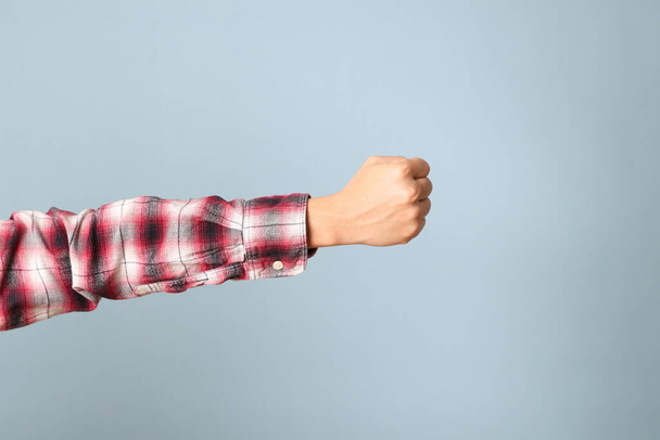 The Asian man hand with plaid shirt showing on the blue background. - Foto, Bild