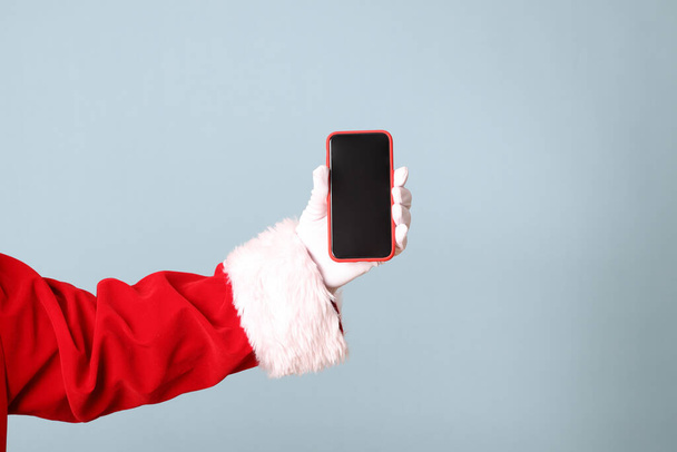 The Santa Claus hand showing on the blue background. - Photo, Image