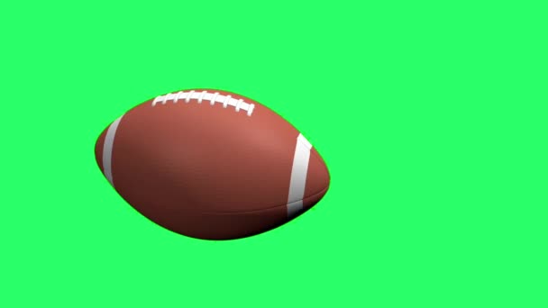 Realistic rugby ball floats into the screen on green background. - Video