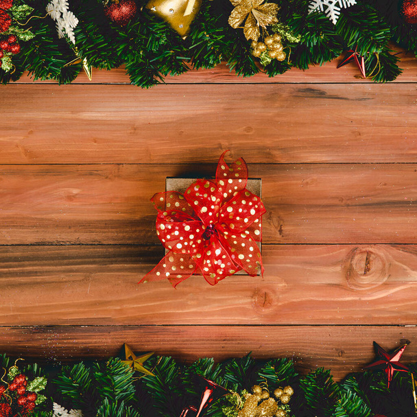 Regalar caja regalo con cinta de color rojo sobre fondo de madera con árbol de Navidad y adornos tradicionales accesorios de Navidad con espacio de copia. Concepto de feliz y alegre en el festival. - Foto, imagen