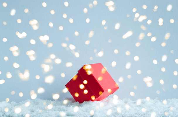 A gift box is lying on the snow. Golden bokeh. Snow cover. - Foto, immagini