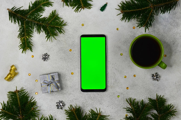 green screen technology cell phone on christmas decoration table top view flat lay, mock up for copy space text, smart phone chroma key, new year online concept no people. - Foto, Imagen
