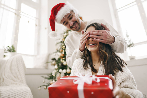 Young cheerful couple in love with present for Christmas - Фото, зображення