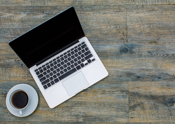 Vista superior do laptop notebook computador com café preto em copo branco no fundo padrão de madeira com espaço de cópia. - Foto, Imagem