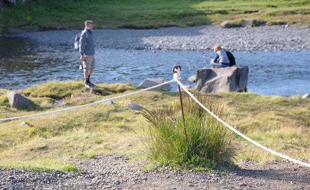 Kirkjufell, Islandia en agosto 7, 2021 - Turistas extranjeros ignorando las fronteras establecidas por el pueblo islandés, cruzando líneas y mientras tanto destorando la naturaleza - Foto, imagen