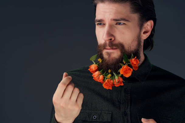 portrait of a man posing flowers in a beard fashion dark background - Фото, зображення