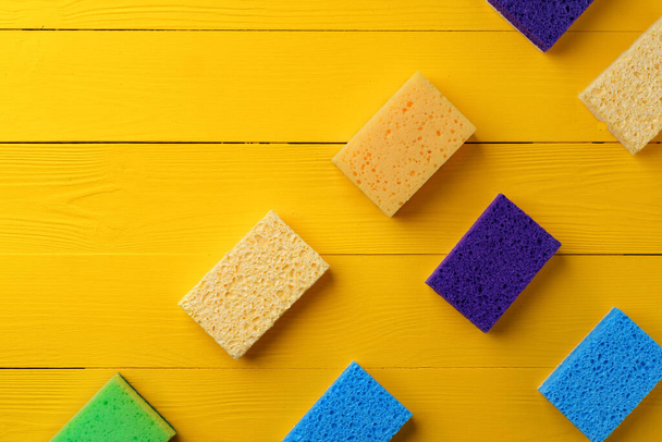 Cleaning sponges on yellow wooden background flat lay - Φωτογραφία, εικόνα