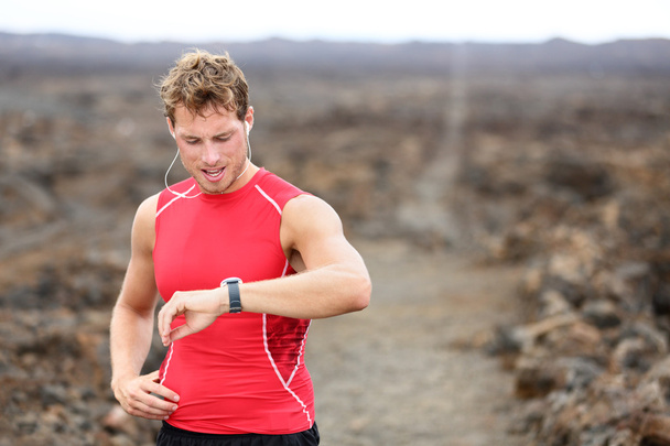 Running looking at heart rate monitor - 写真・画像