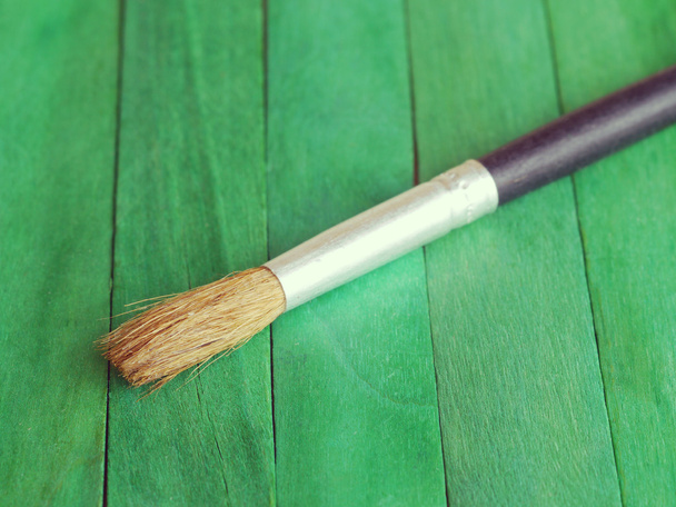 paintbrush on green wood background - Foto, imagen
