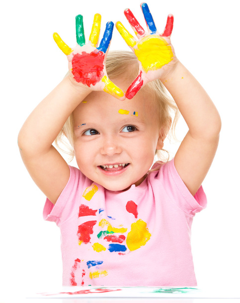 Portrait of a cute little girl playing with paints - 写真・画像